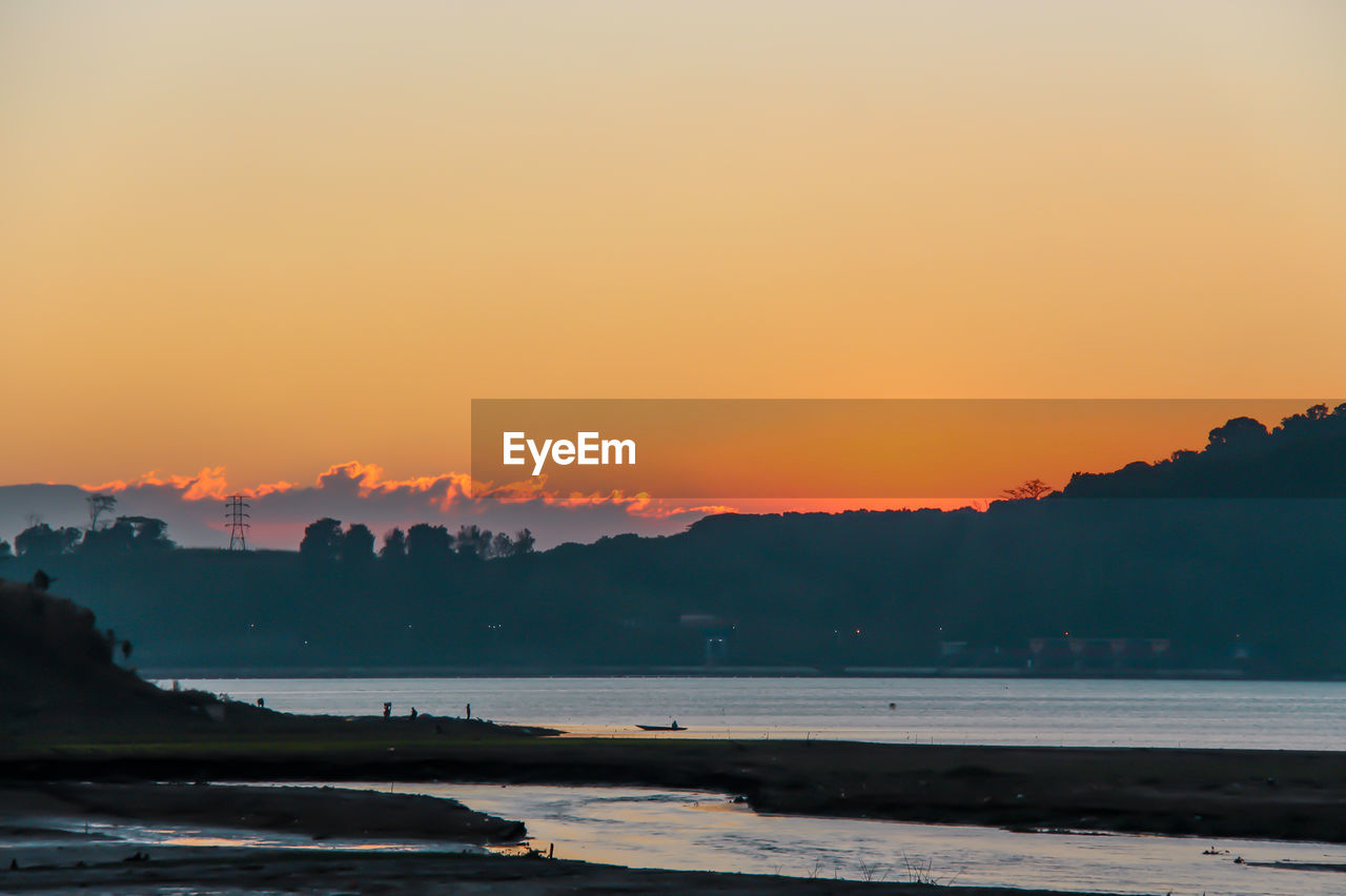 Scenic view of sea against orange sky