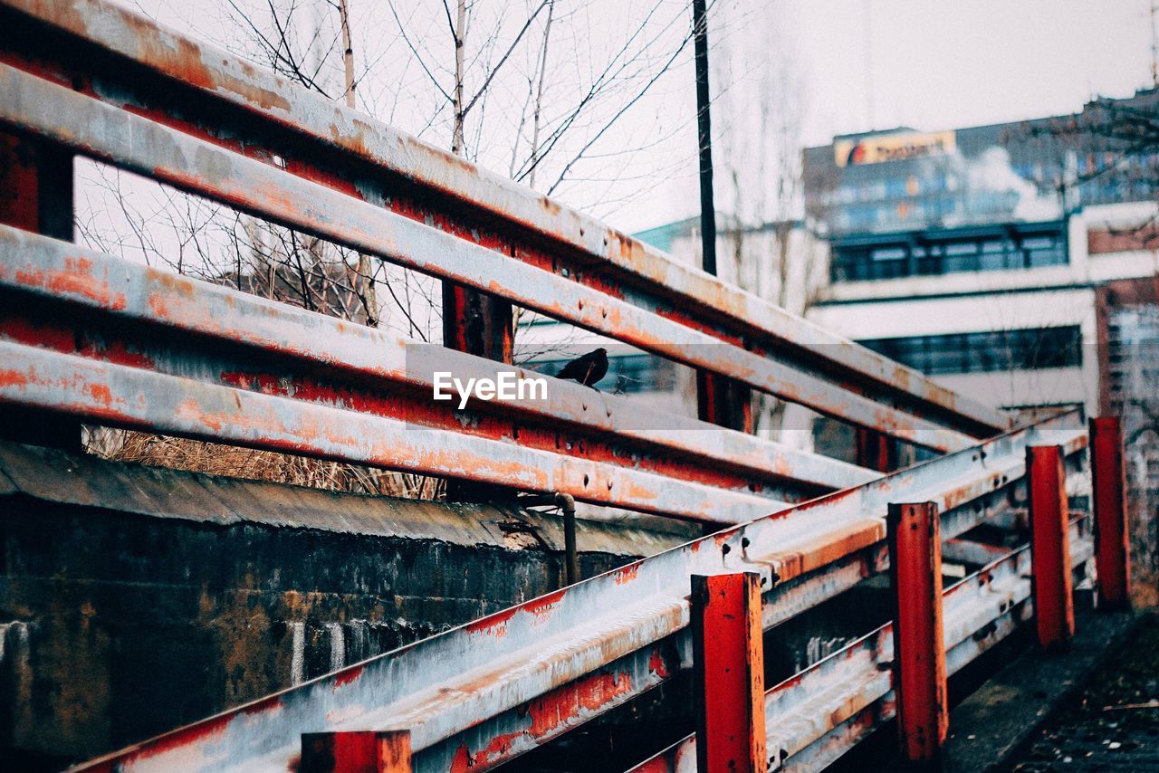 Metal railing by walkway against sky