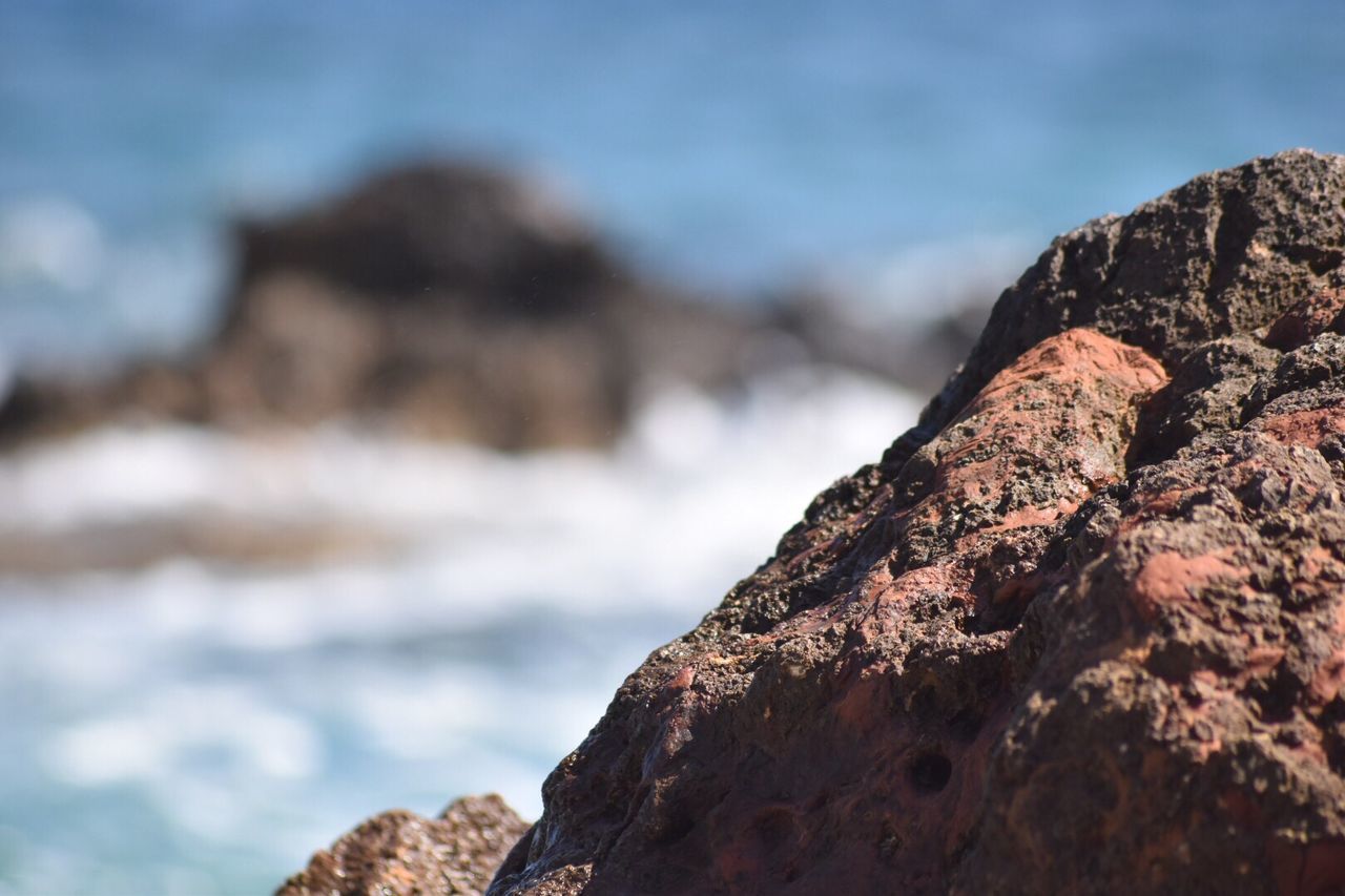 Close-up of rock formation by sea against sky