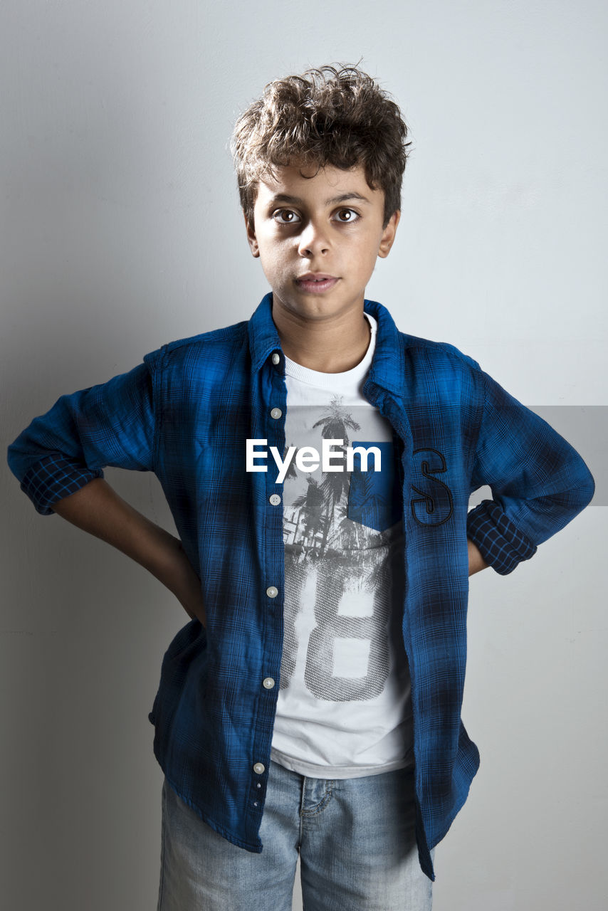 Portrait of young man standing against wall