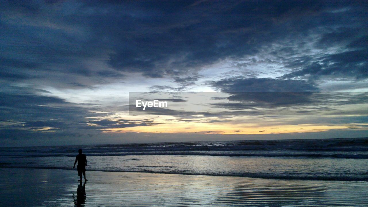 SILHOUETTE PEOPLE ON CALM BEACH