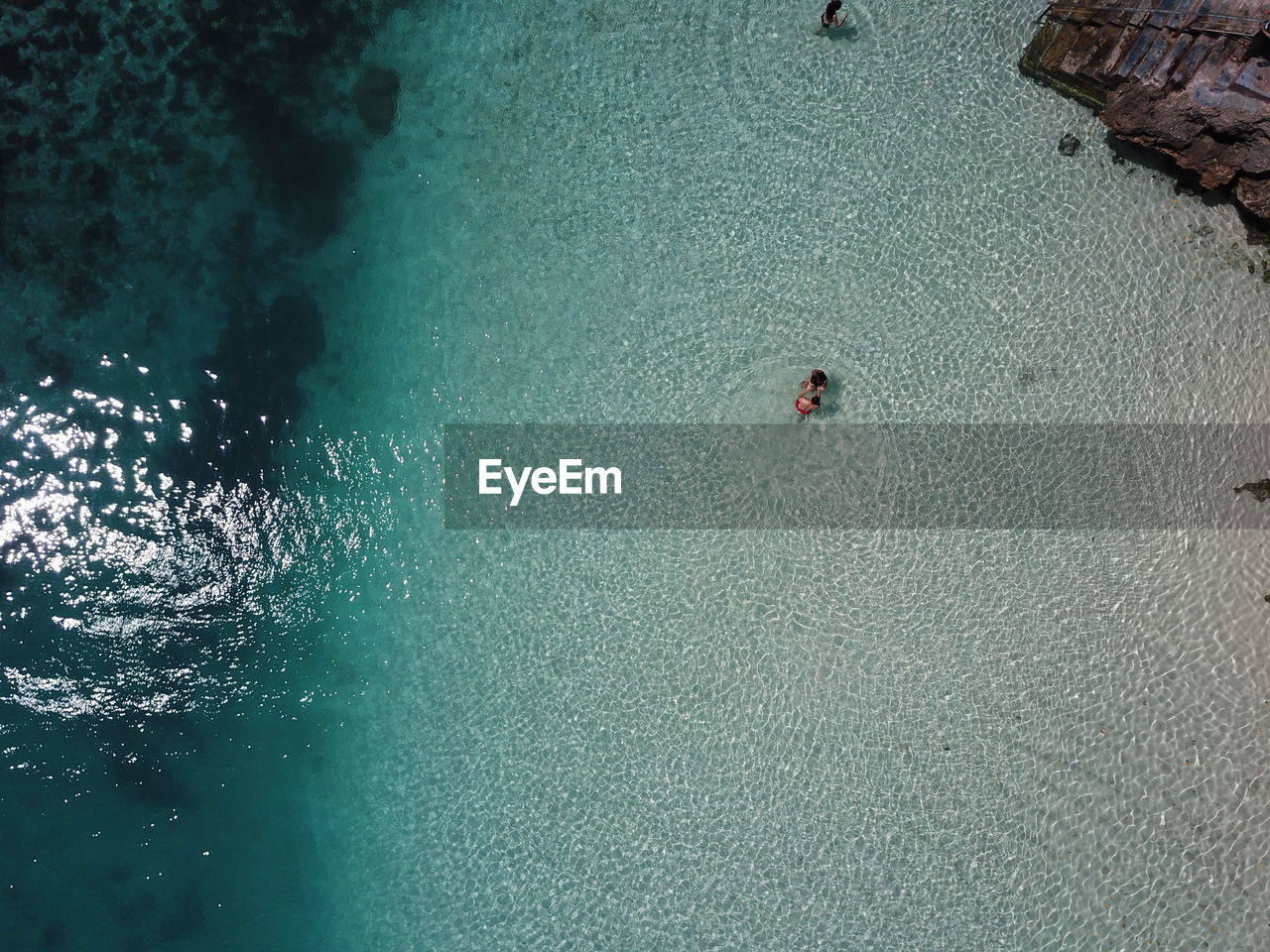 HIGH ANGLE VIEW OF PEOPLE SWIMMING UNDERWATER