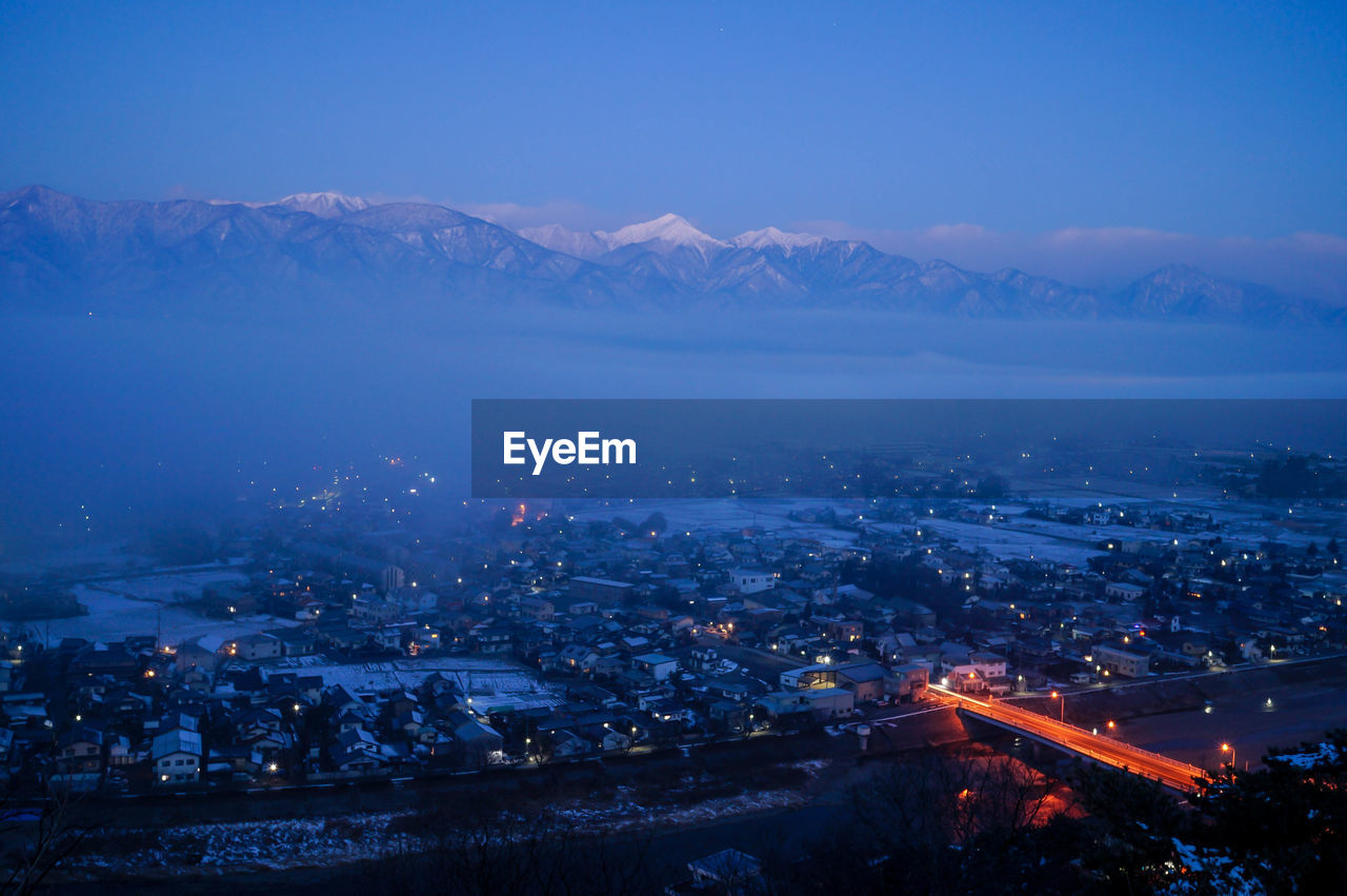 Aerial view of illuminated city against sky at night