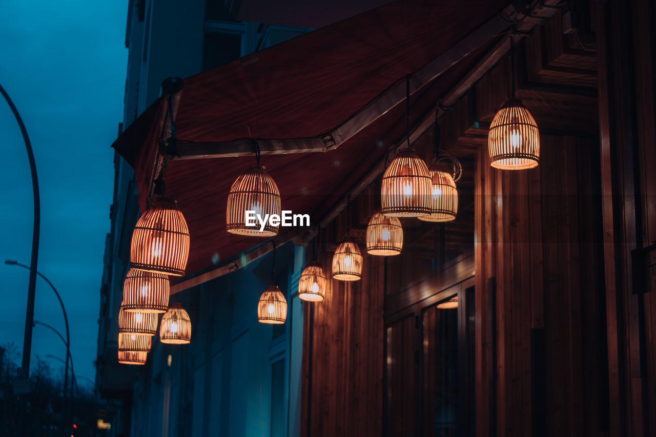 Low angle view of illuminated lanterns hanging on building