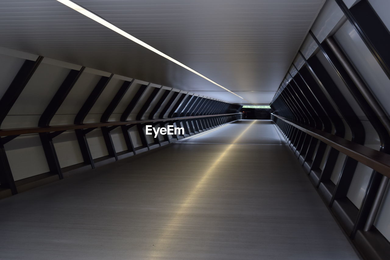 Diminishing perspective of empty footbridge at night