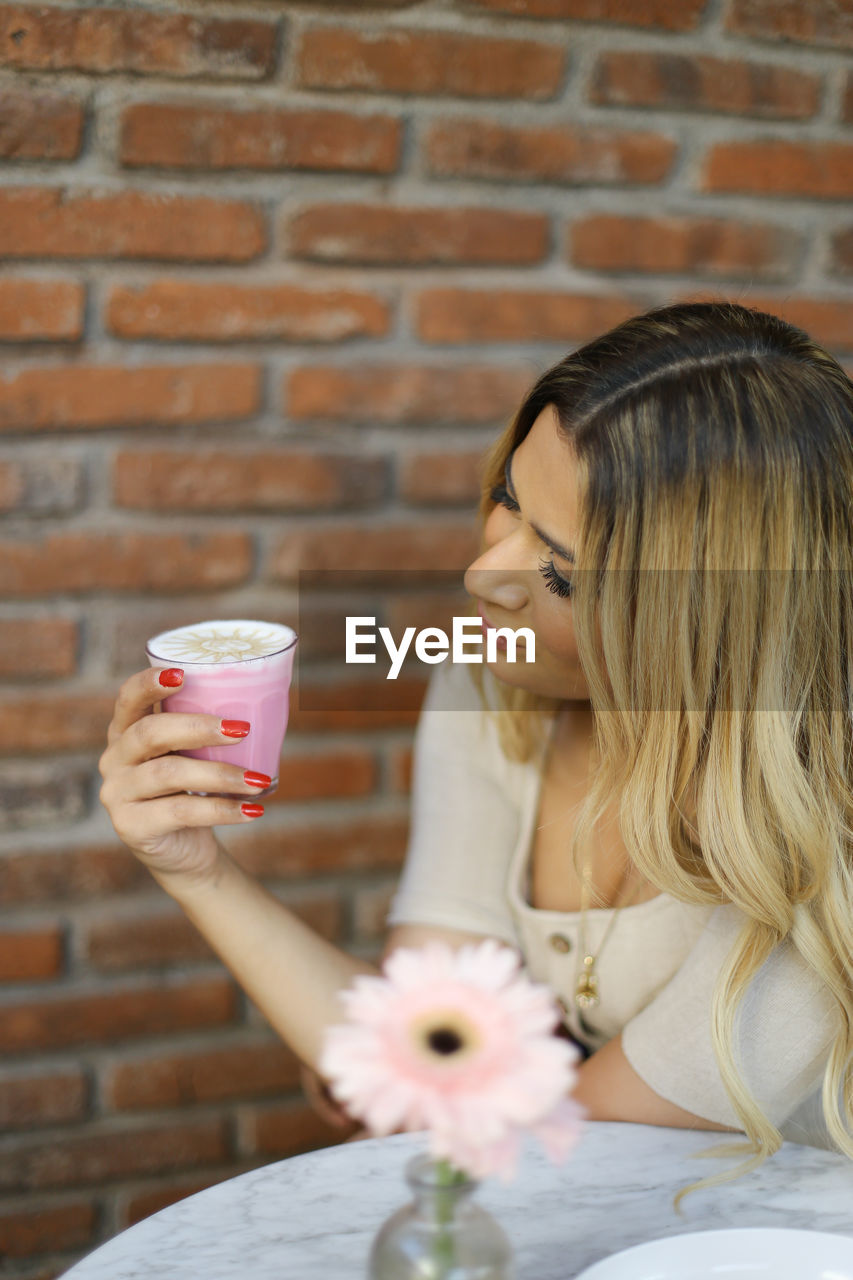 CLOSE-UP OF WOMAN HOLDING COFFEE CUP