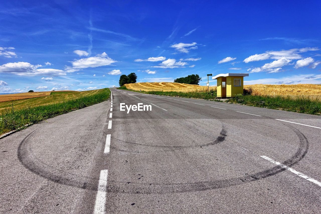 Road by landscape against blue sky