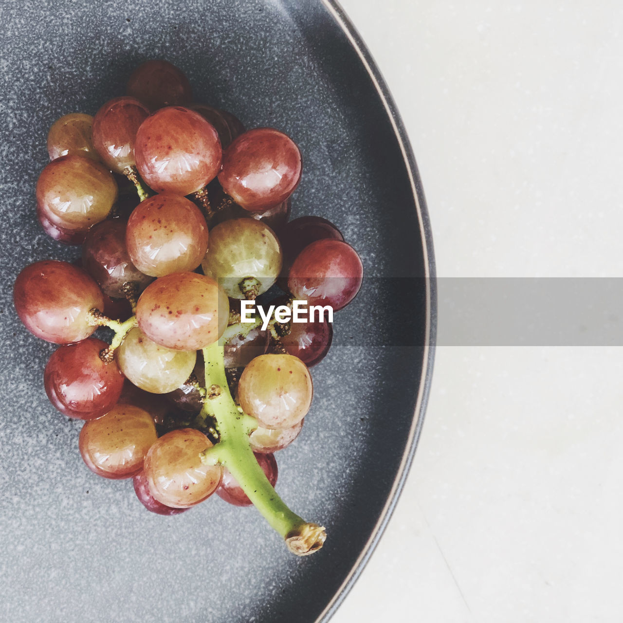 DIRECTLY ABOVE SHOT OF GRAPES IN BOWL ON TABLE