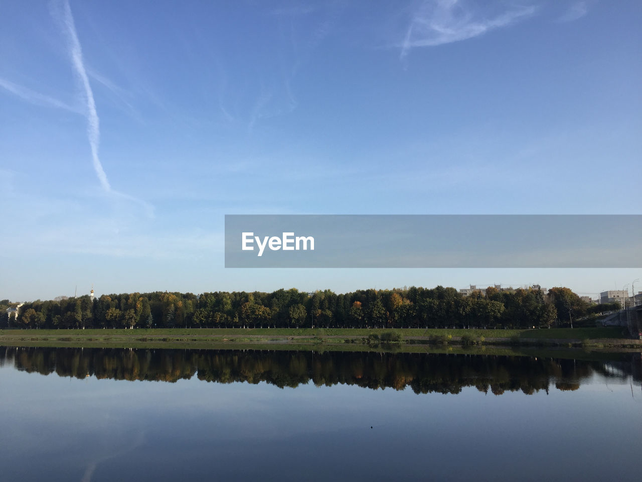 REFLECTION OF TREES IN LAKE AGAINST SKY