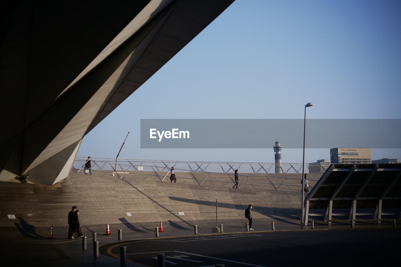 PEOPLE WALKING ON BRIDGE AGAINST SKY