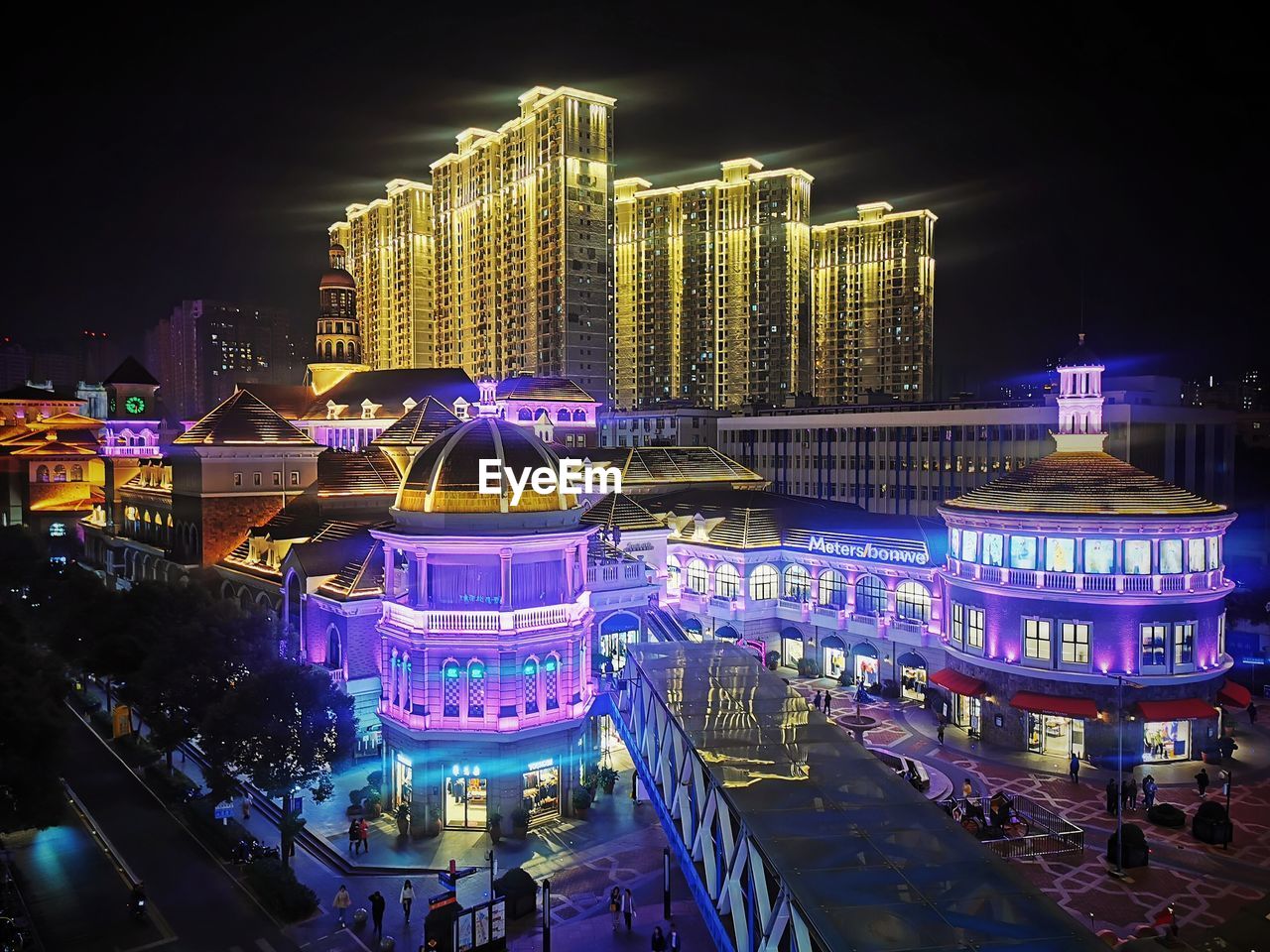 HIGH ANGLE VIEW OF ILLUMINATED CITY BUILDINGS AT NIGHT