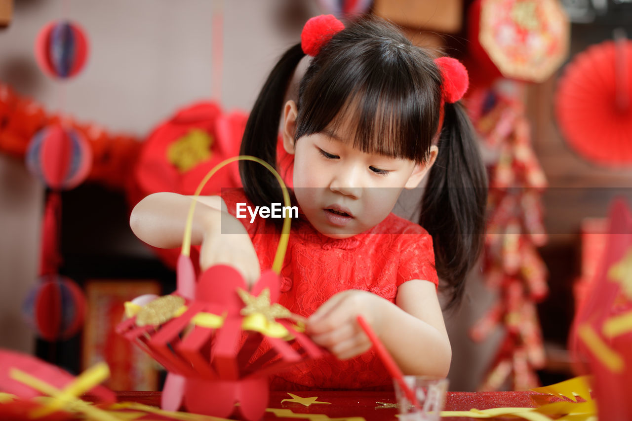 Young chinese girl making traditional chinese lantern for celerating chinese new year