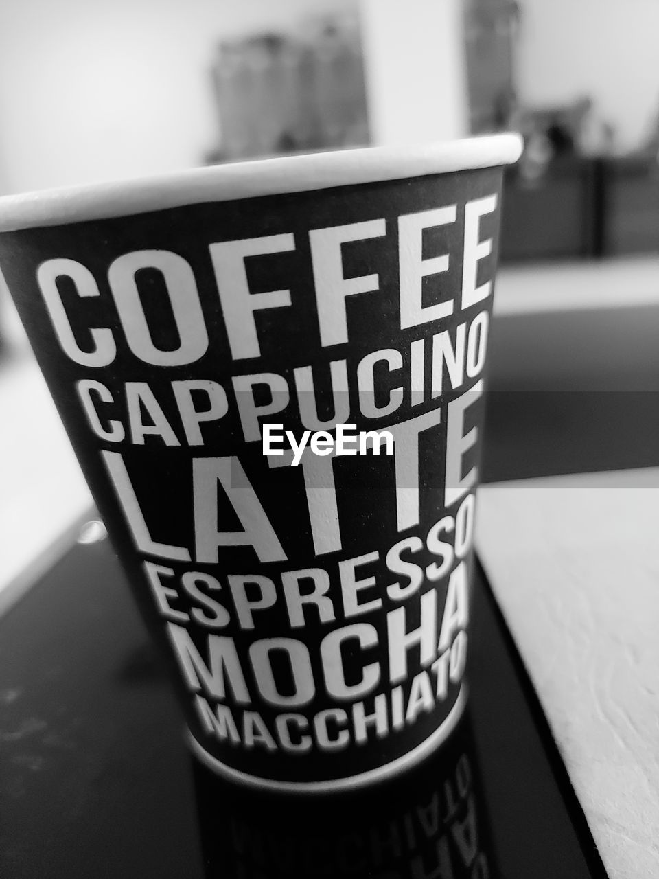 black, white, black and white, text, monochrome photography, monochrome, focus on foreground, western script, communication, drink, no people, indoors, close-up, food and drink, cup, pint, coffee cup