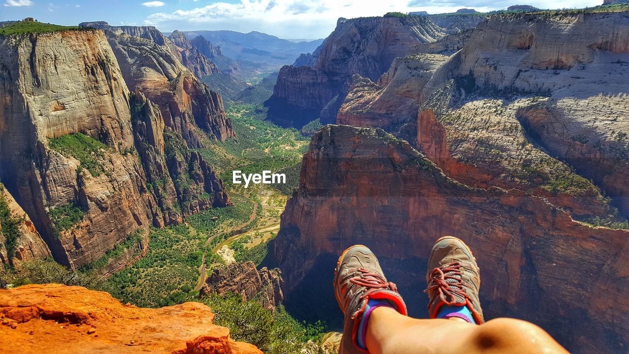 Low section of person against rocky mountains