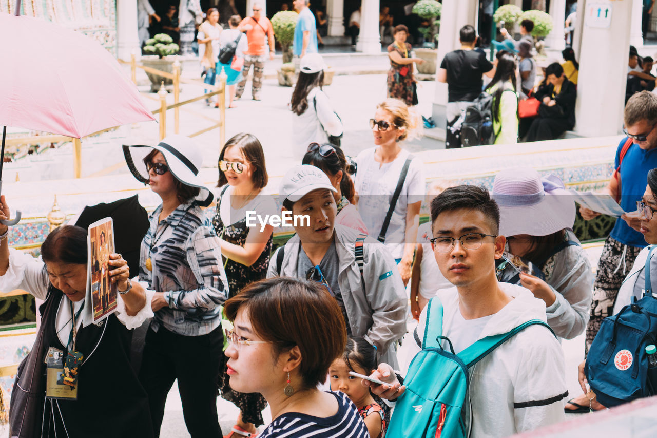 GROUP OF PEOPLE PHOTOGRAPHING AT CITY