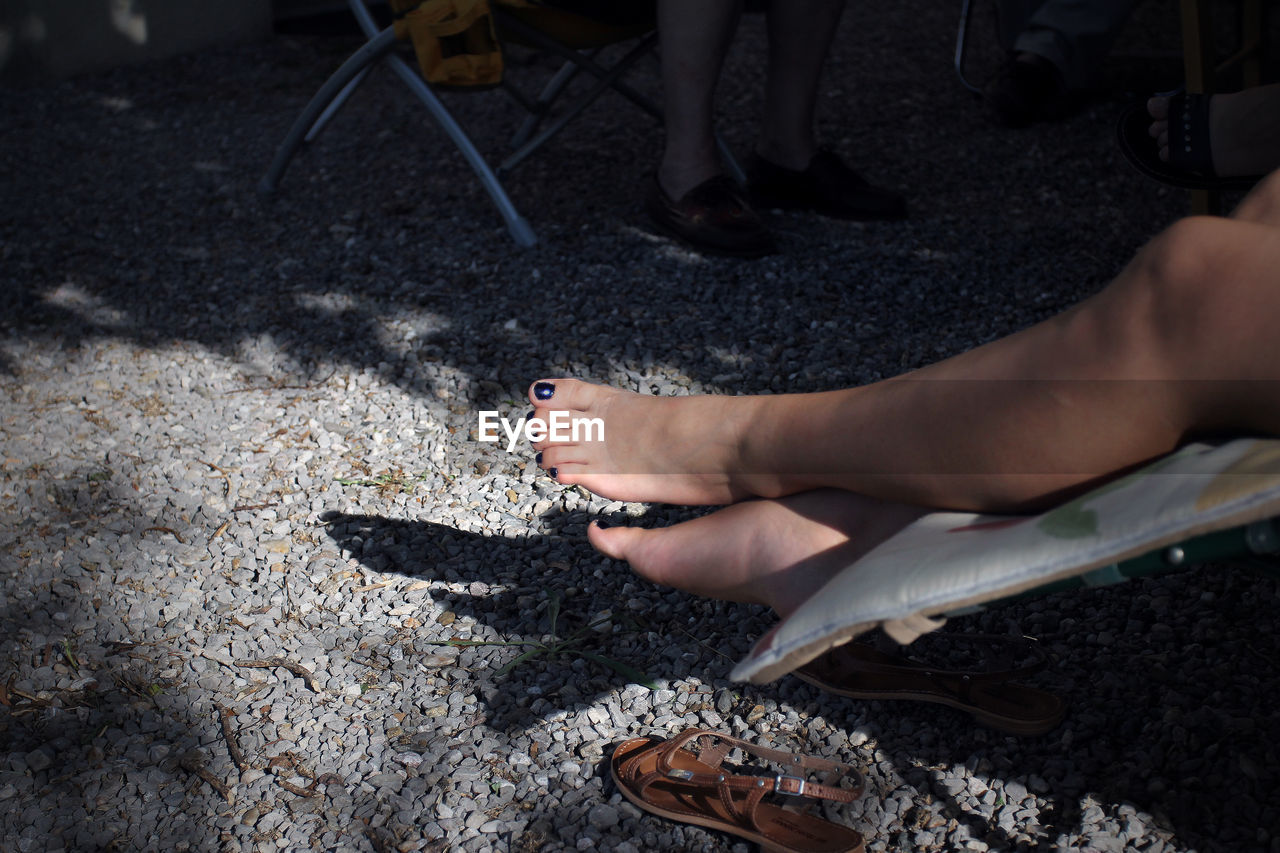 LOW SECTION OF WOMAN WITH SHADOW ON FLOOR