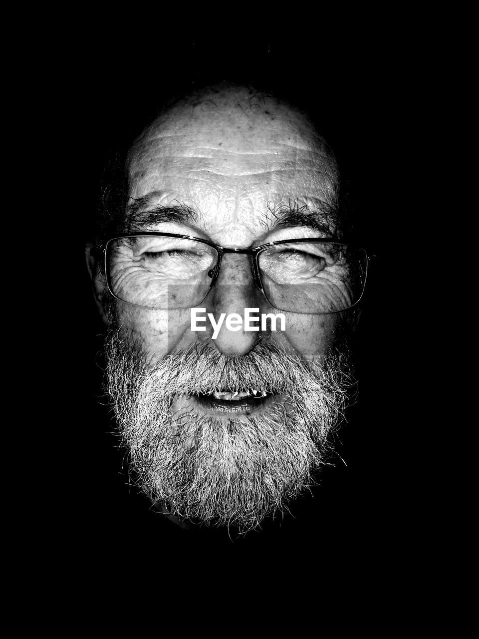 Close-up of bearded man against black background