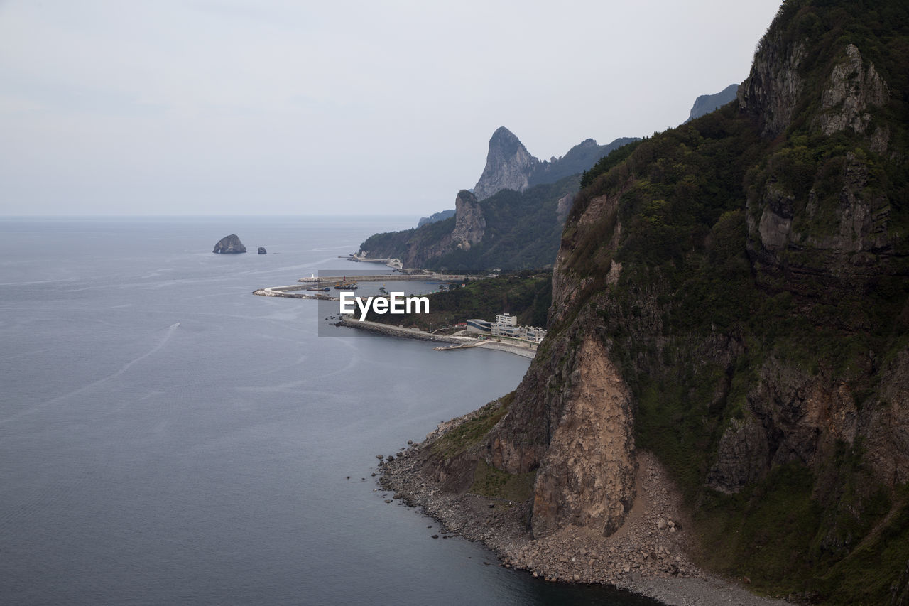 High angle view of mountain by sea against clear sky