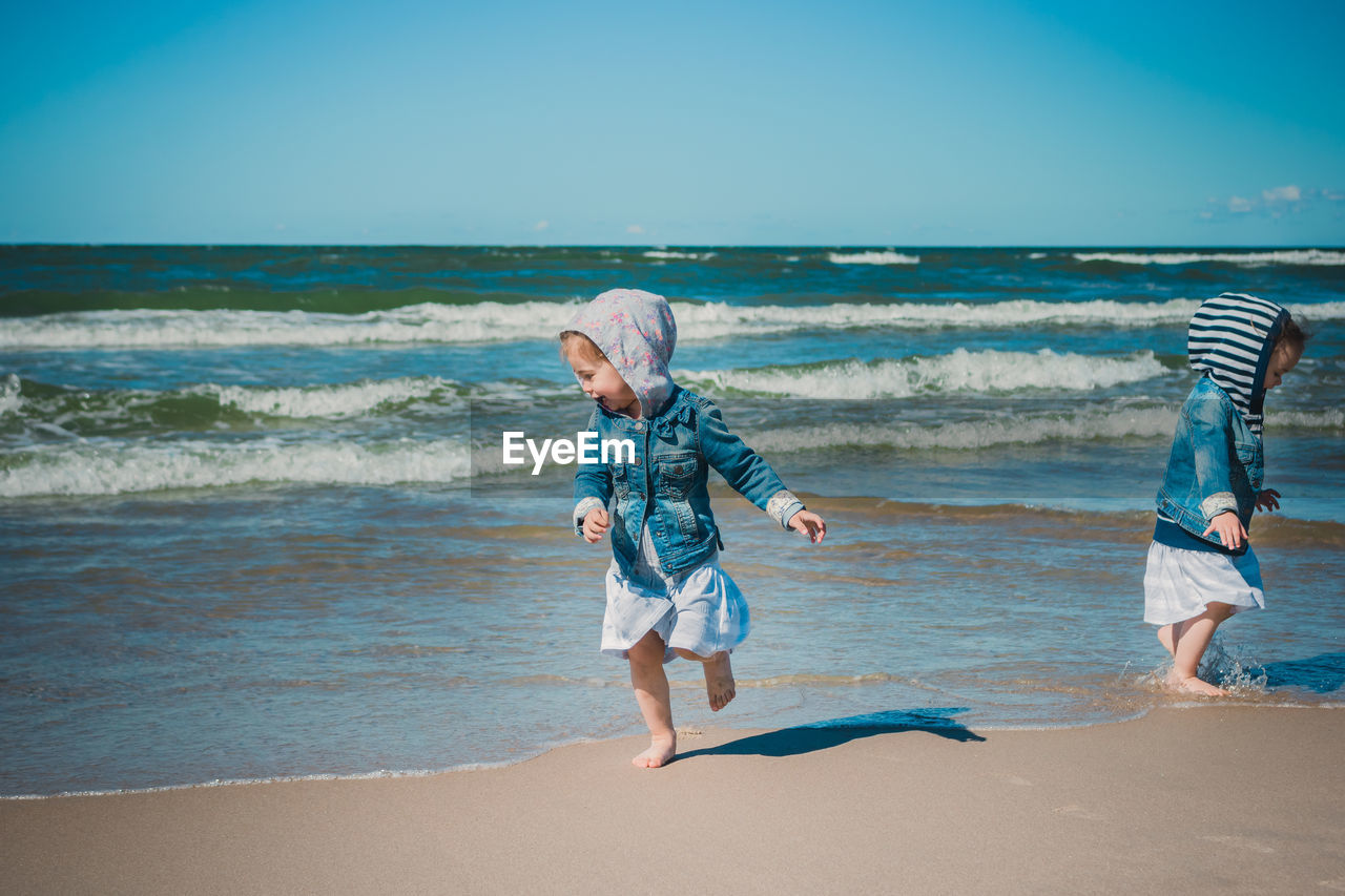 FULL LENGTH OF GIRL ON BEACH AGAINST SEA