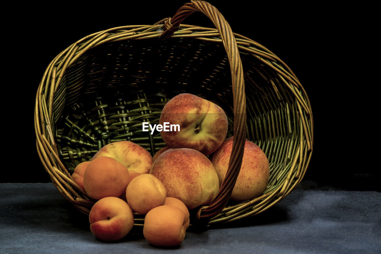 Apricots and peaches on wicker basket