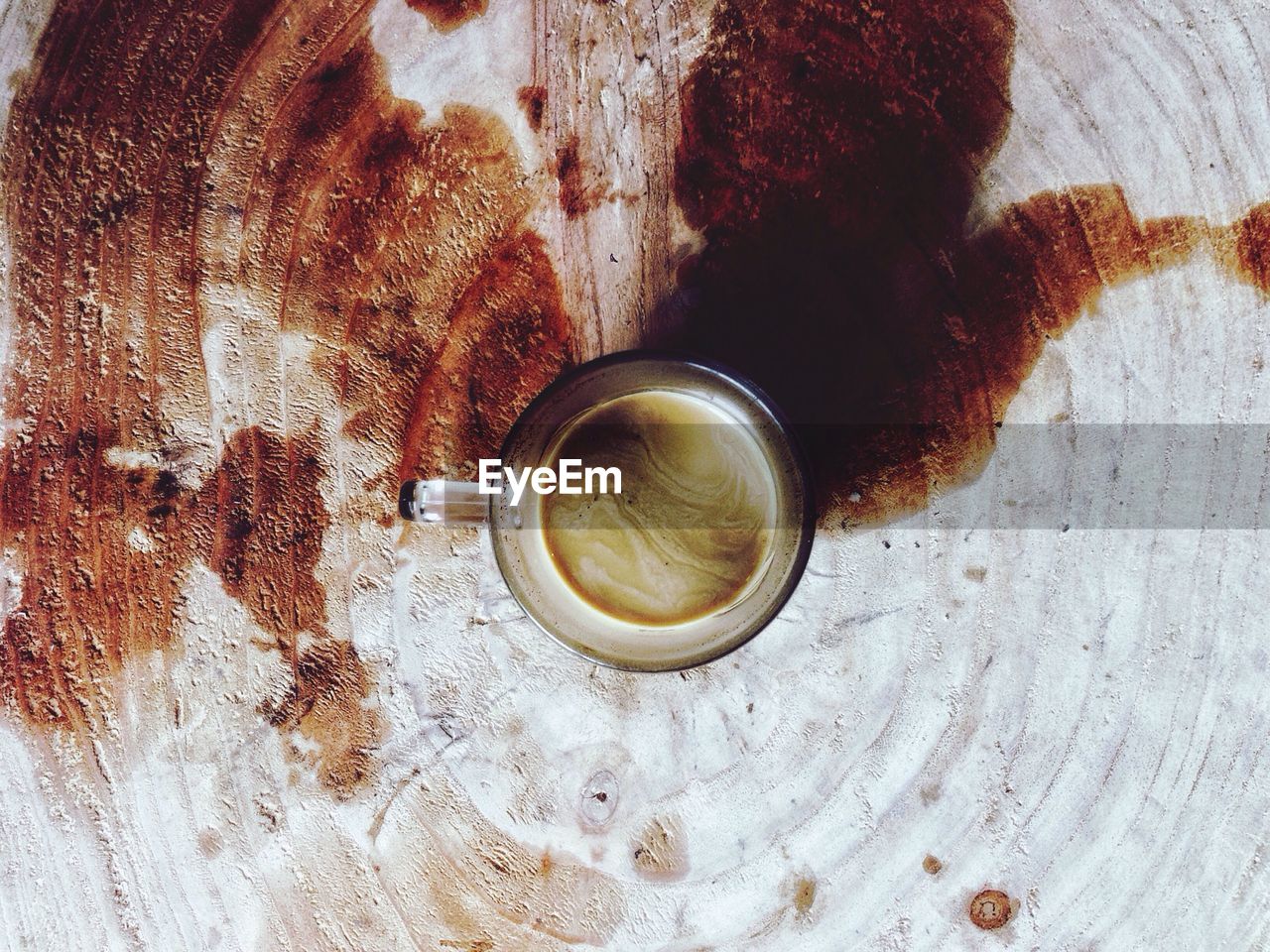 Glass with coffee on stained wood