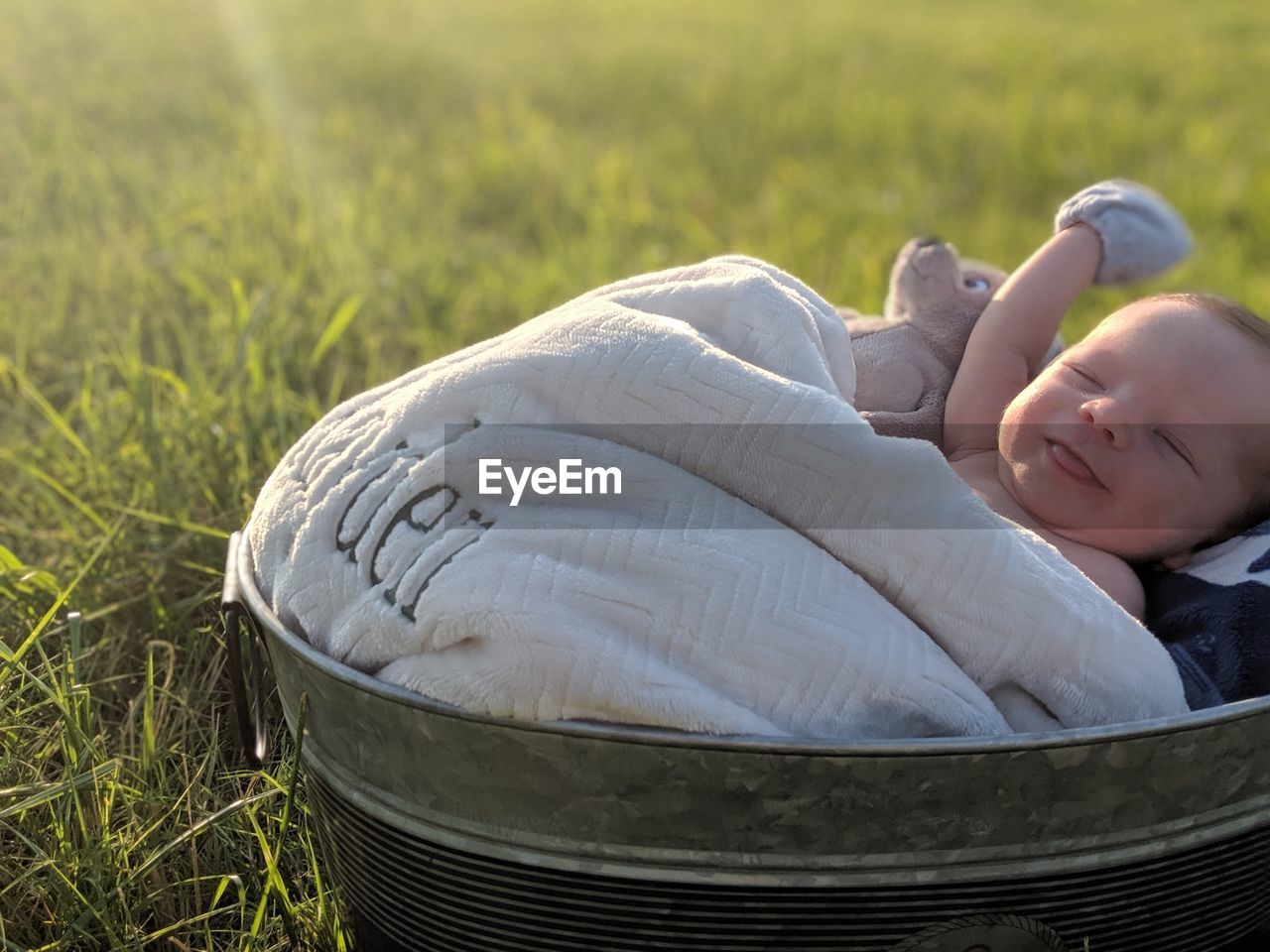 High angle view of boy lying in container on grassy land