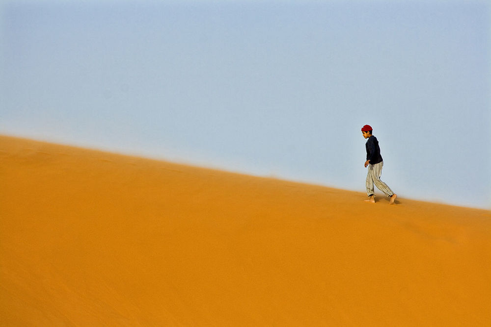 REAR VIEW OF MAN WALKING ON LAND