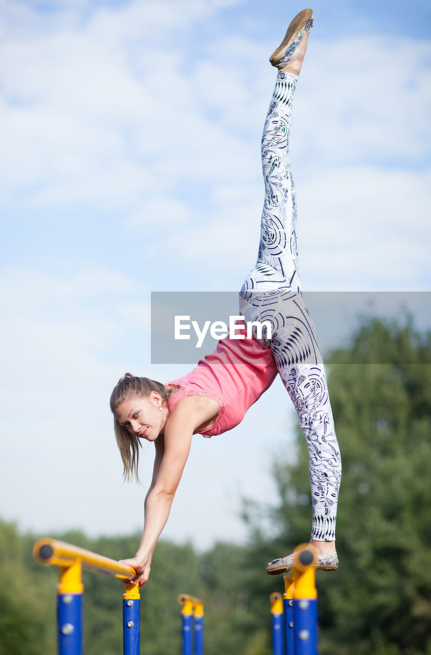 Low angle view of woman exercising at playground