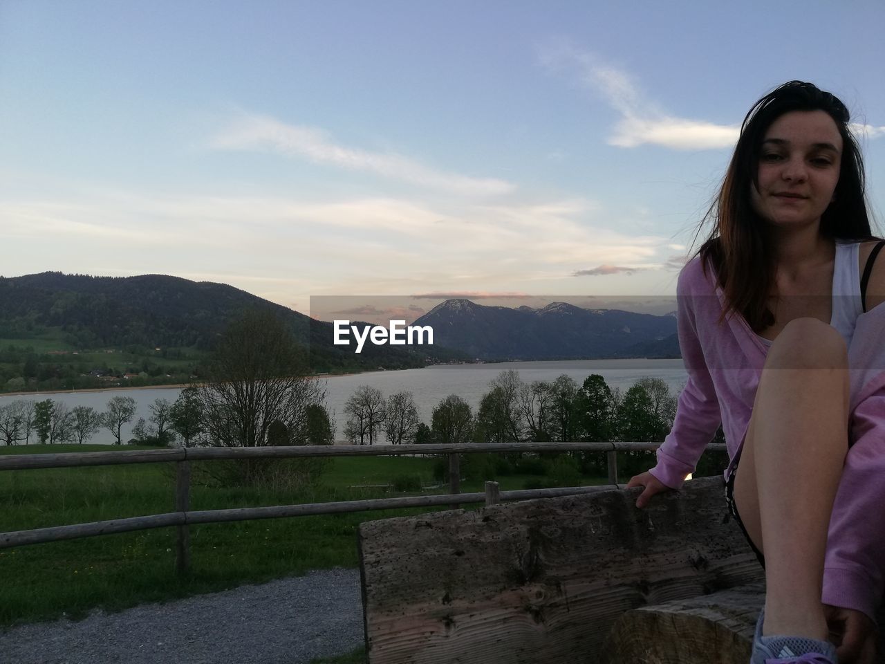 WOMAN STANDING ON RAILING AGAINST SKY