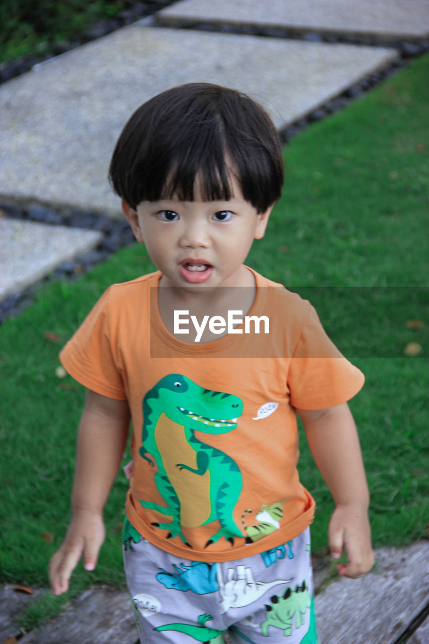 Portrait of cute boy standing on field