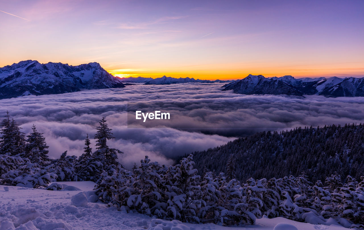 Scenic view of snow covered mountains against sky during sunset