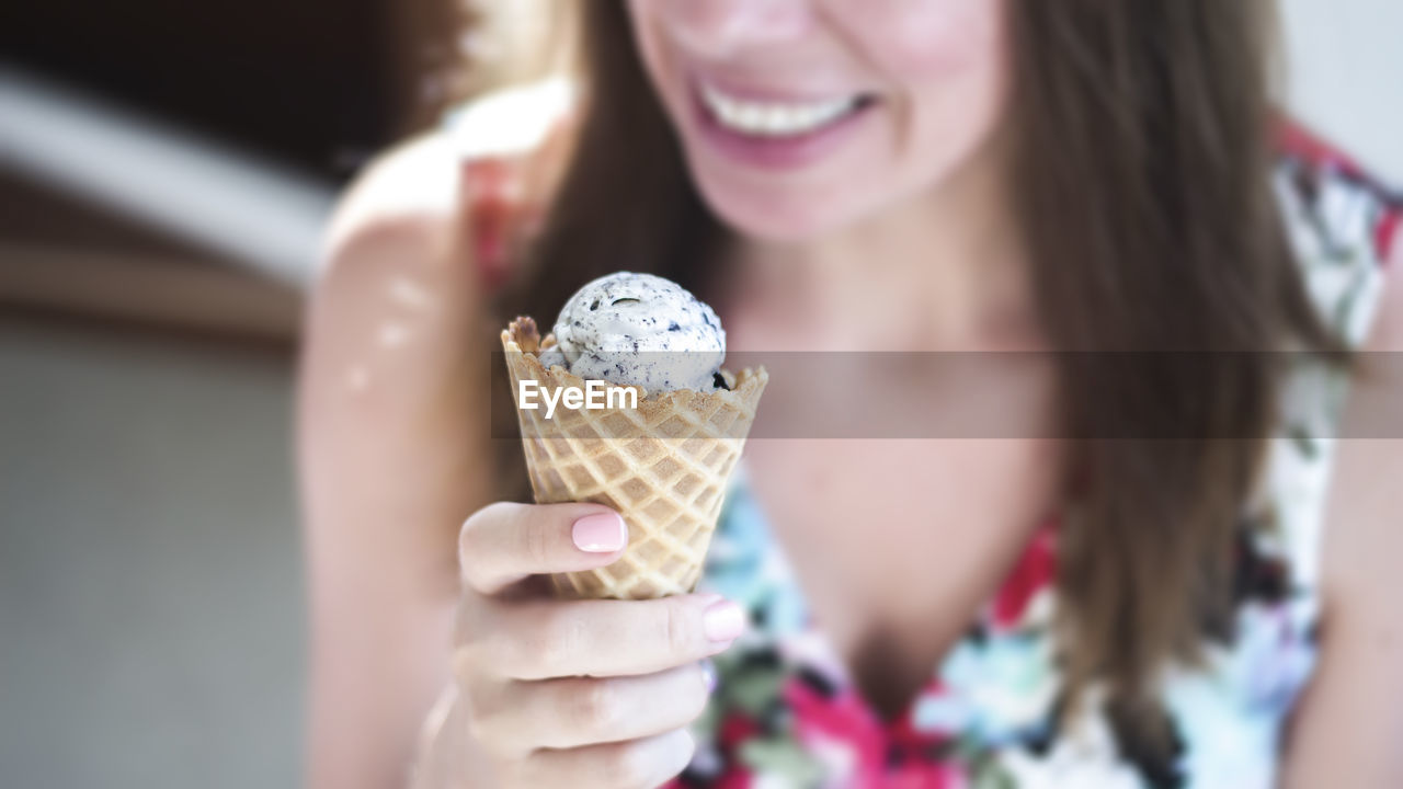 Midsection of woman holding ice cream cone