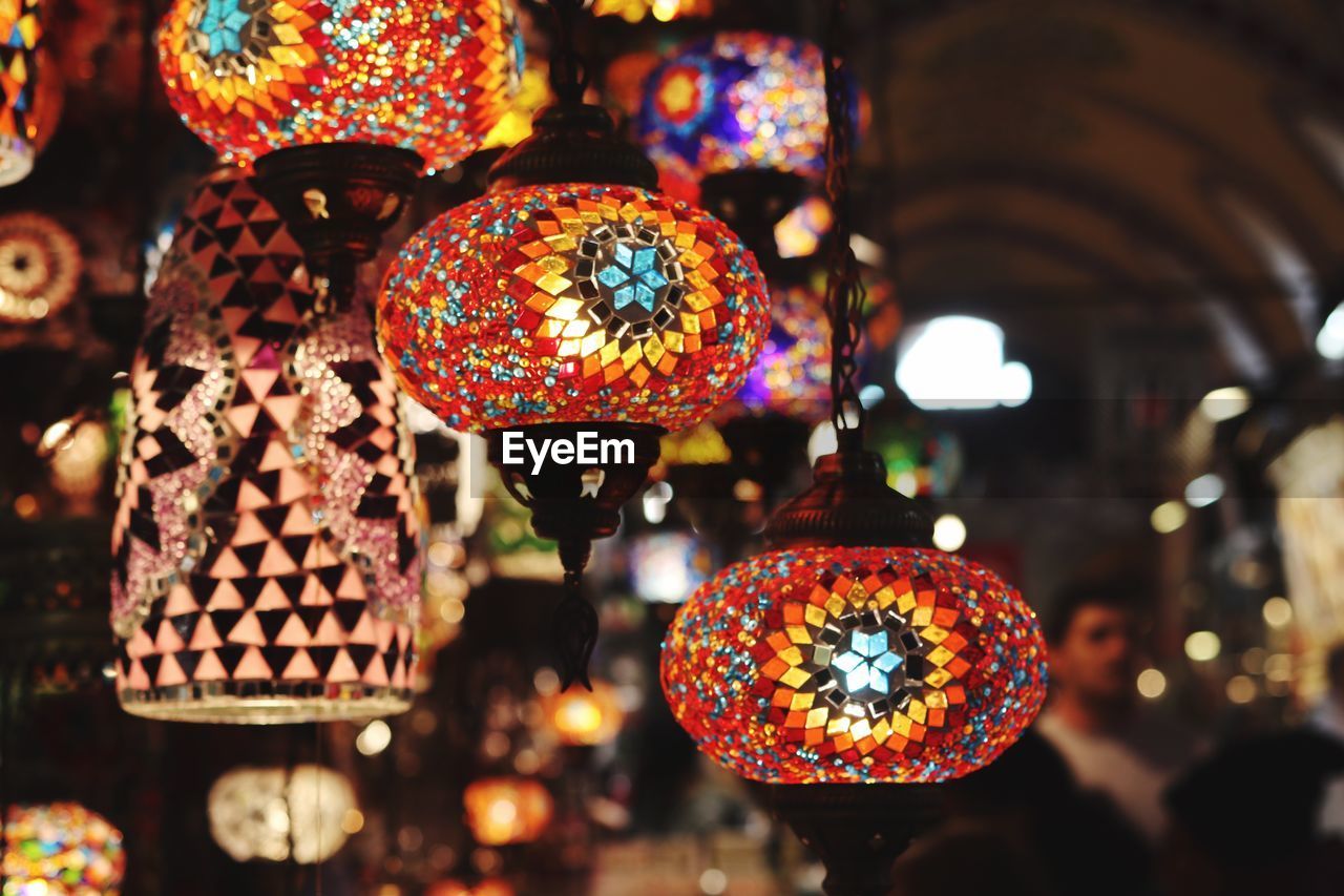 CLOSE-UP OF ILLUMINATED LANTERNS HANGING AT MARKET STALL