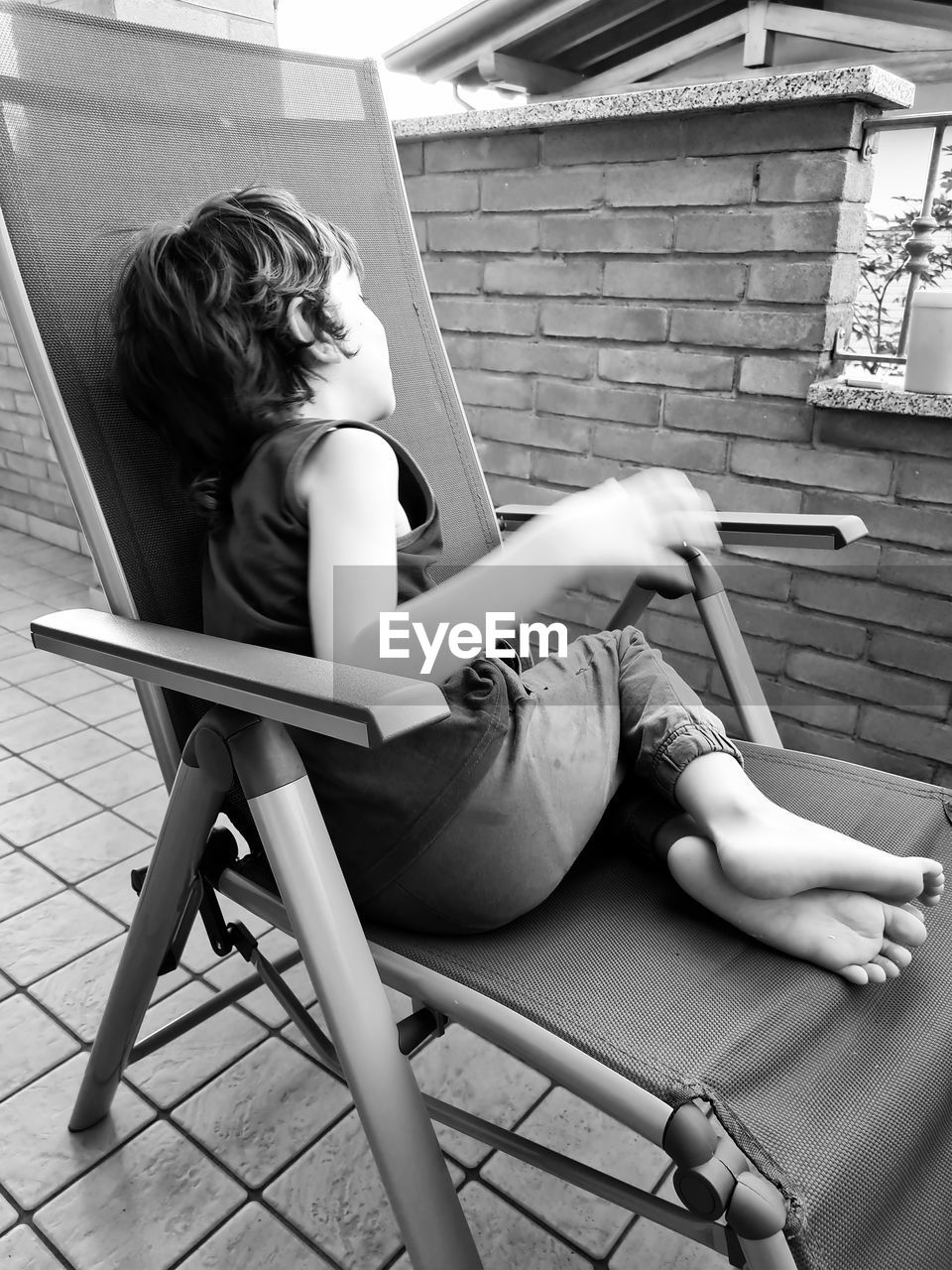 Side view of woman sitting on chair