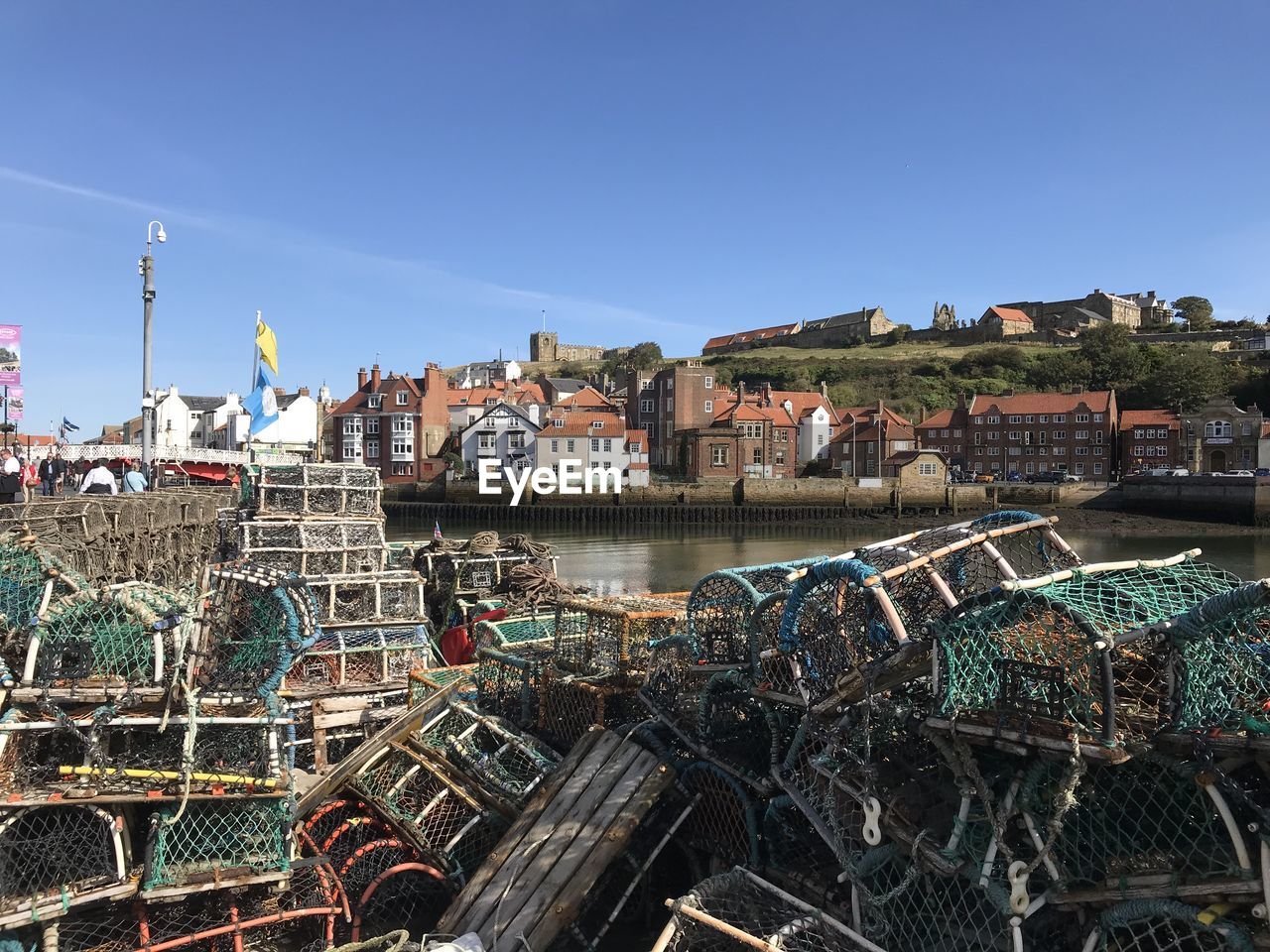 Scenic view of harbor against buildings against clear blue sky whitby harbour. north yorkshire 
