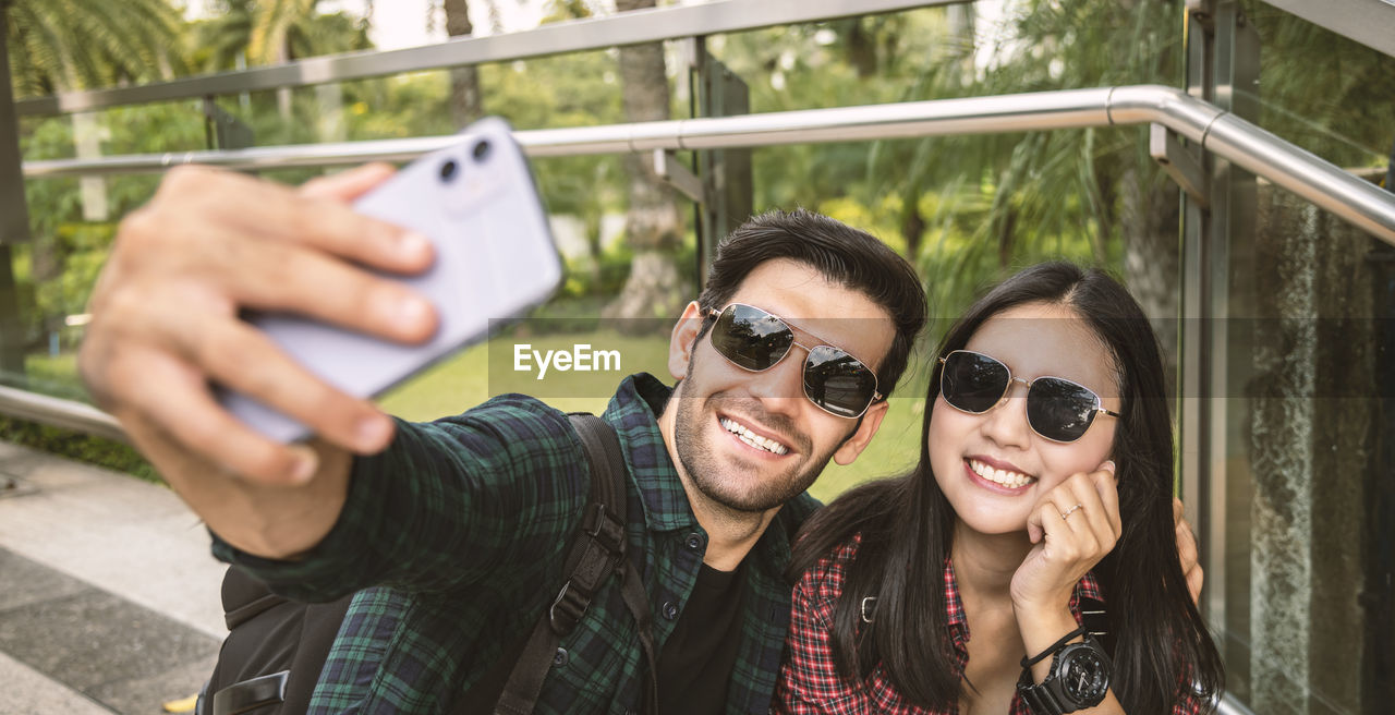 Young couple doing selfie while standing outdoors