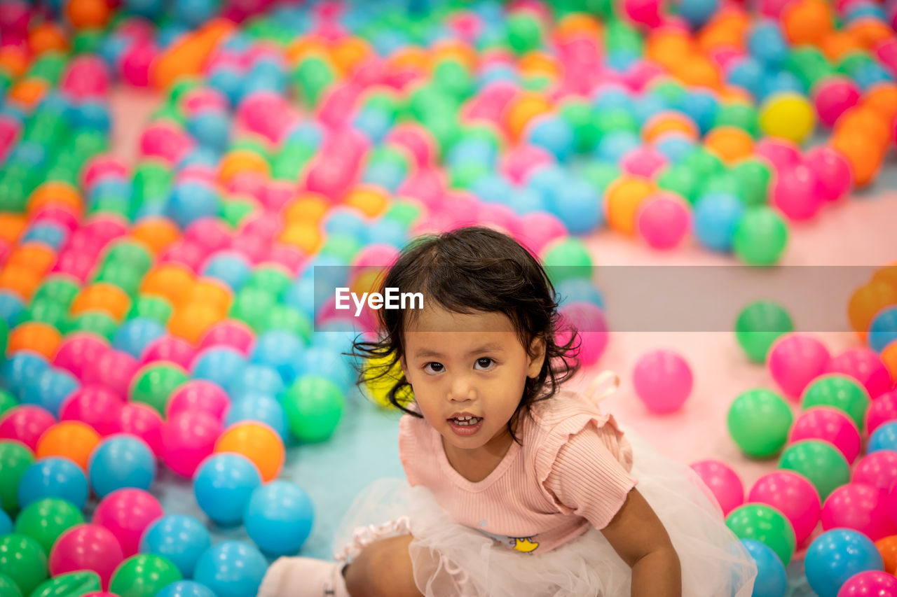 Portrait of smiling girl enjoying in ball pool