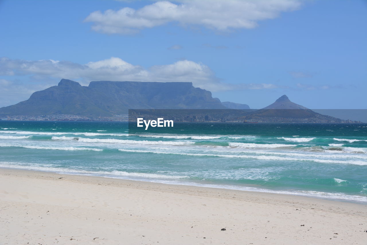 SCENIC VIEW OF BEACH BY MOUNTAINS AGAINST SKY