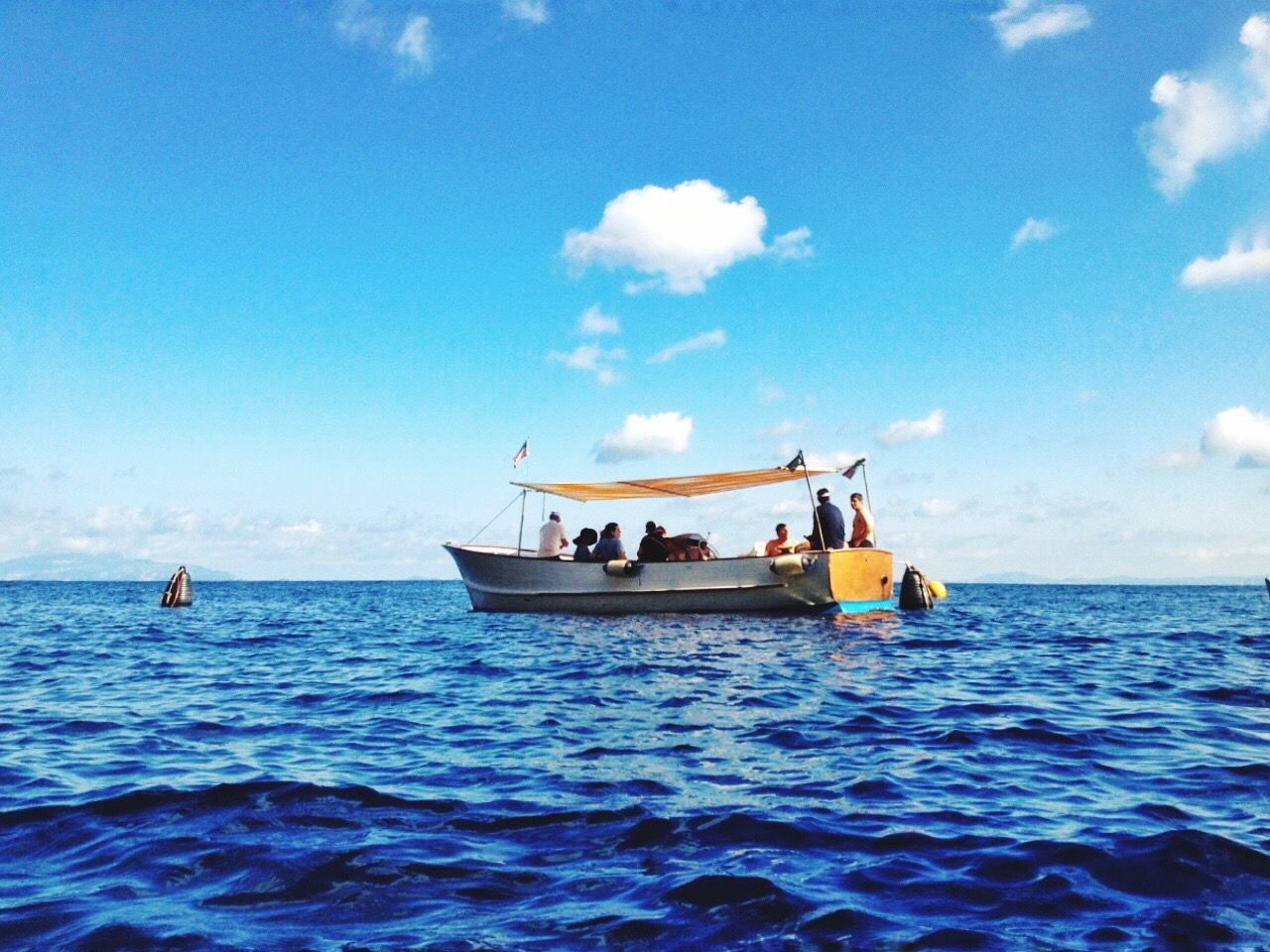 People on boat sailing in sea against sky