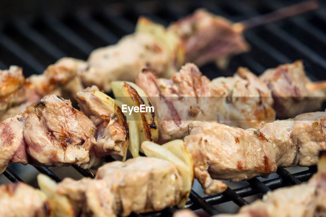 CLOSE-UP OF MEAT COOKING ON BARBECUE