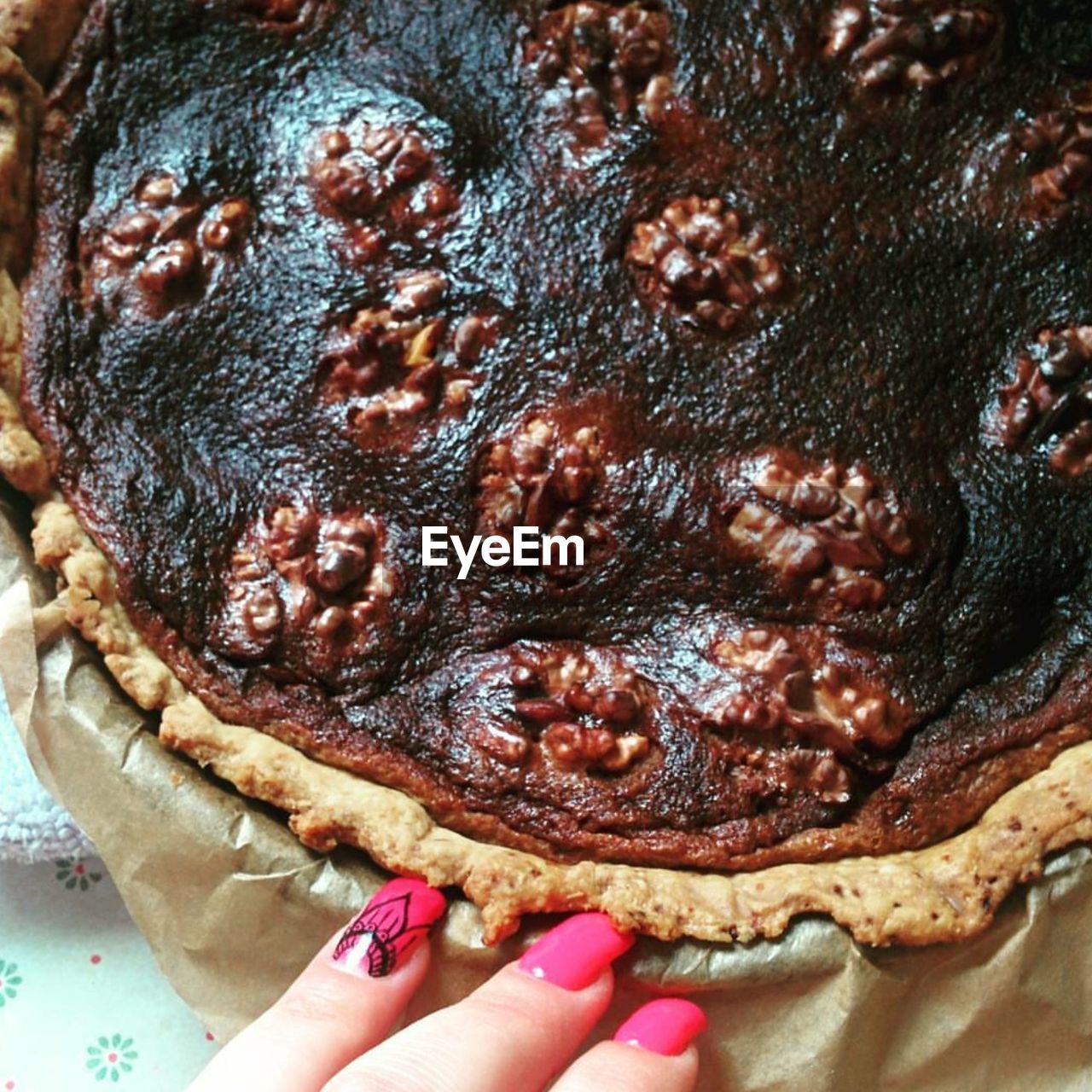 CLOSE-UP OF HAND HOLDING CAKE