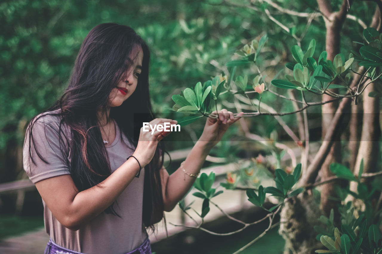 MIDSECTION OF WOMAN HOLDING PLANTS