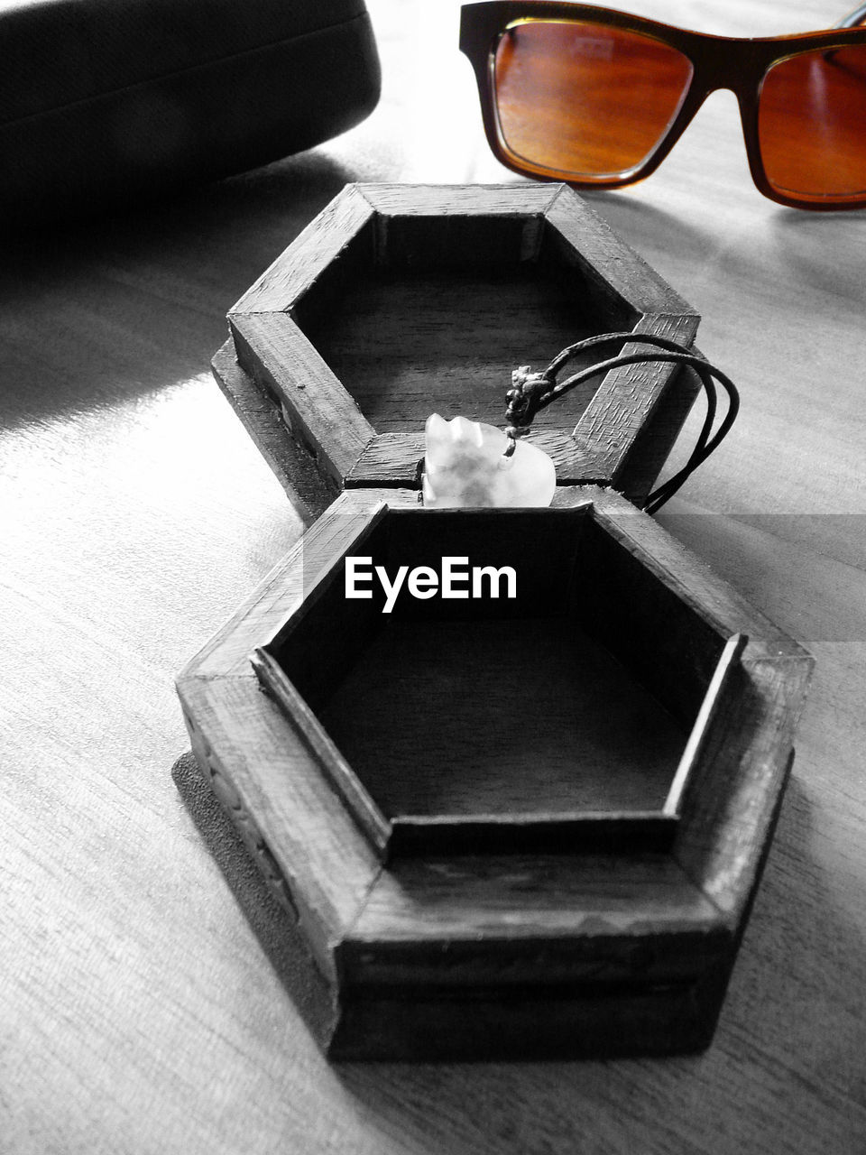 HIGH ANGLE VIEW OF SUNGLASSES AND TABLE ON WOOD