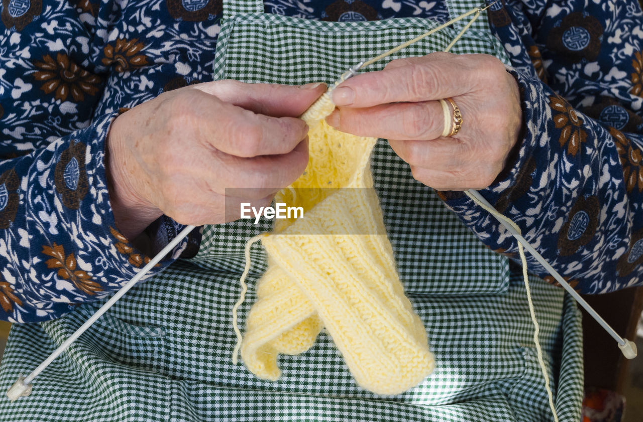 Midsection of woman knitting wool