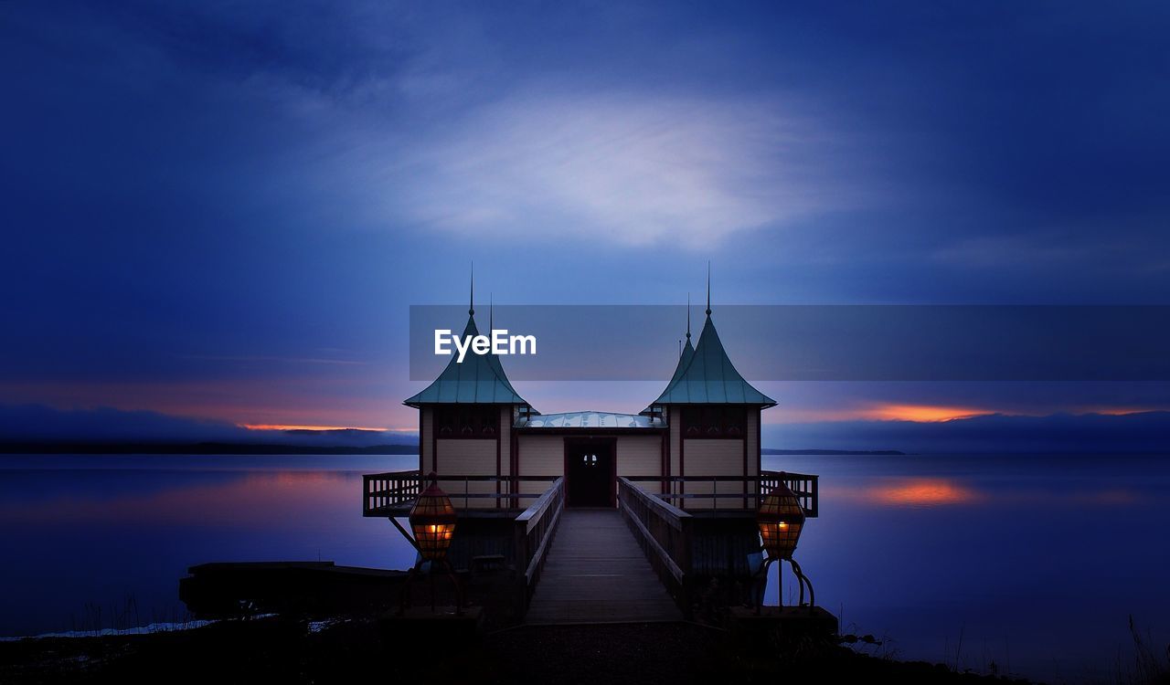 Bathhouse at lake siljan against purple sky during sunset