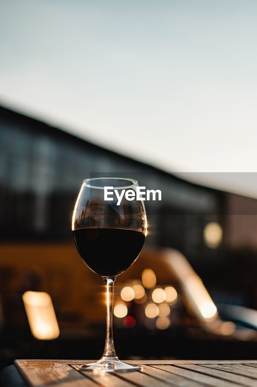 Close-up of wineglass on table against sky