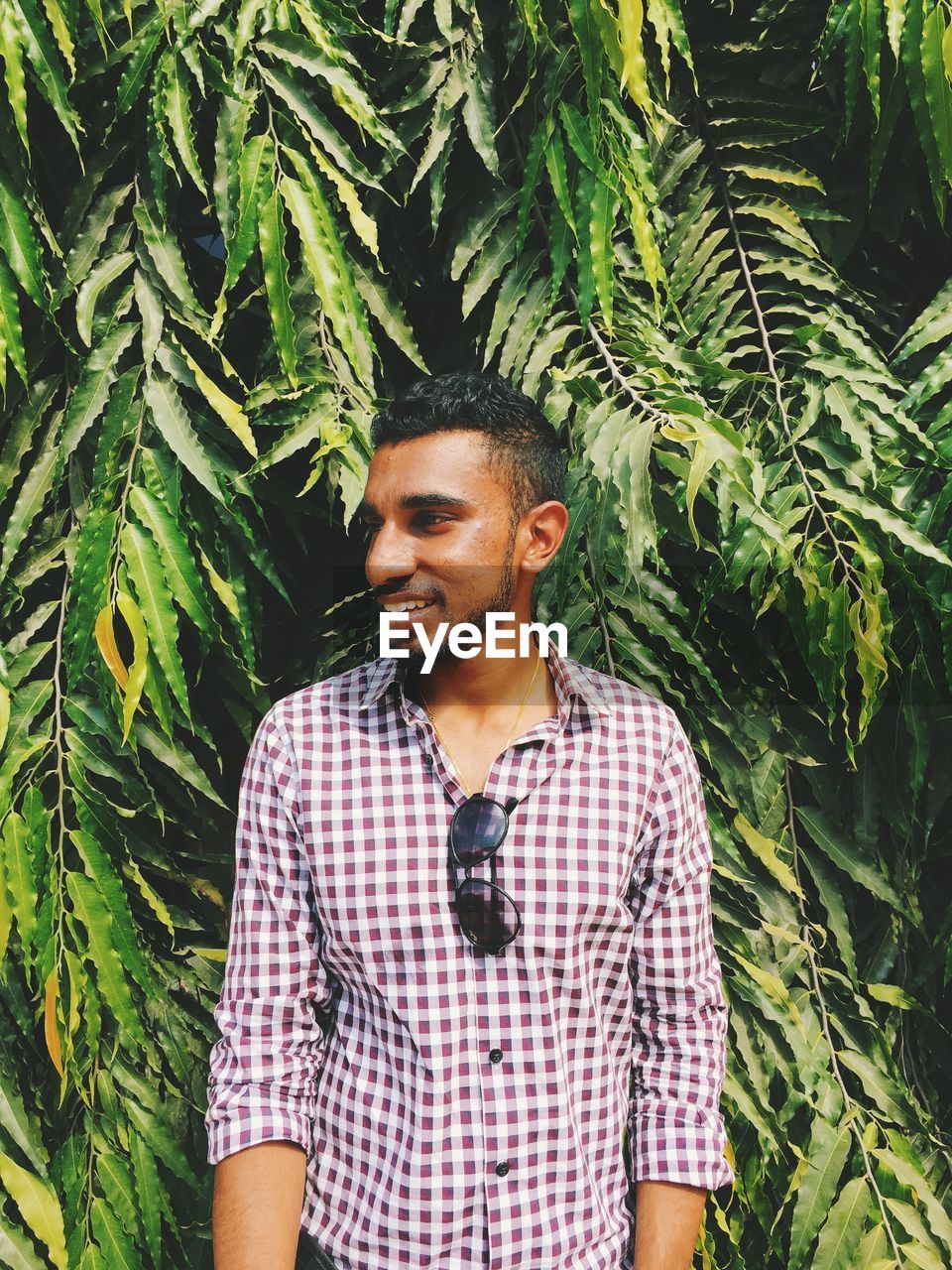 YOUNG WOMAN STANDING IN PARK