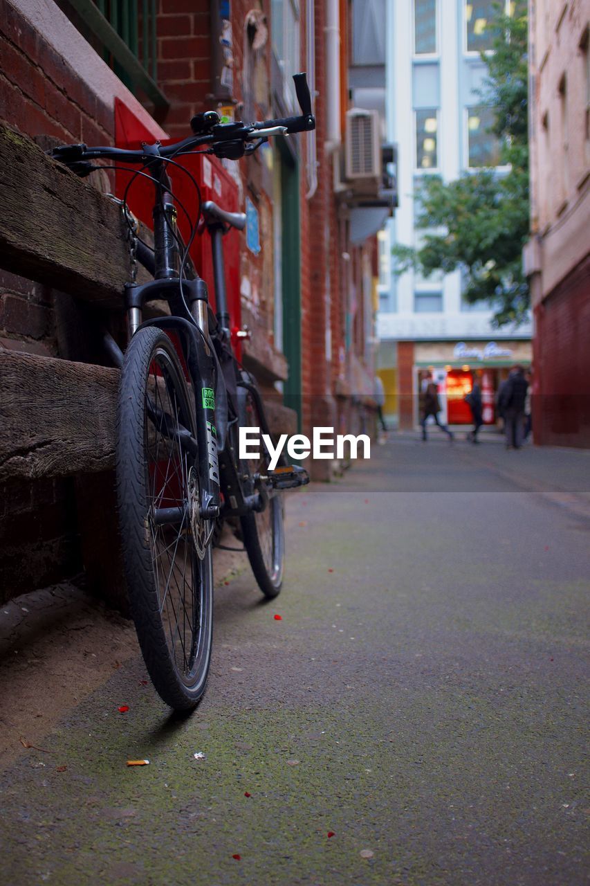 BICYCLE PARKED AGAINST BUILDING