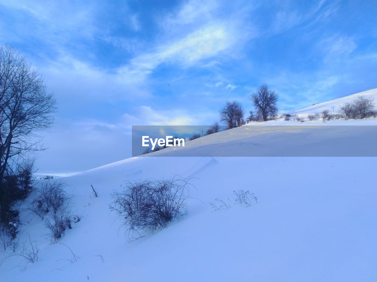 SNOW COVERED LANDSCAPE AGAINST SKY