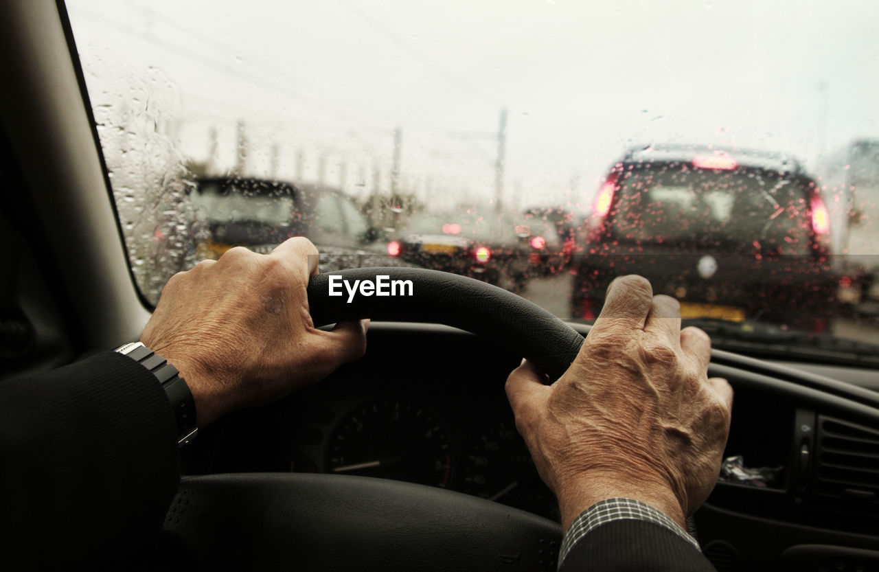 Cropped hands of man driving car